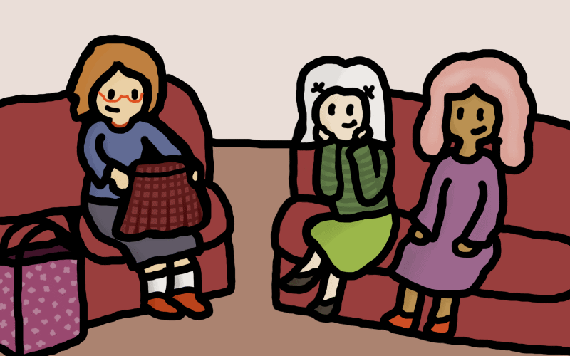 Kay, Lauren, and Suzy from Libretta sitting on sofas, watching Kay opening her birthday gifts and holding up a skirt.